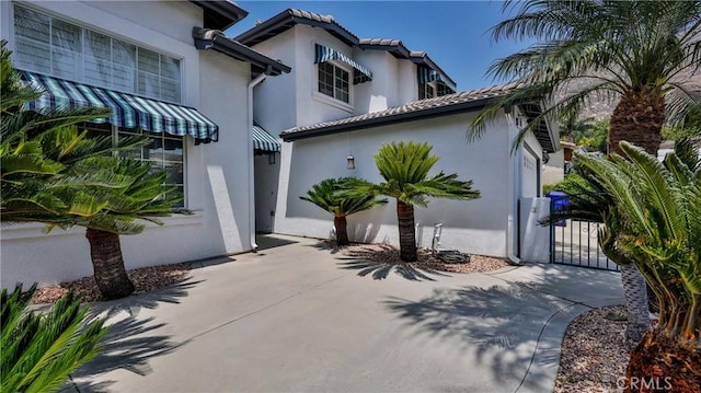 22820 Lark St, Grand Terrace, CA 92313 - view of front facade with stucco siding, concrete driveway, and a gate