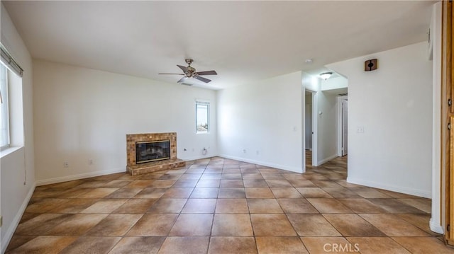 22820 Lark St, Grand Terrace, CA 92313 - unfurnished living room with ceiling fan, a glass covered fireplace, light tile patterned floors, and baseboards