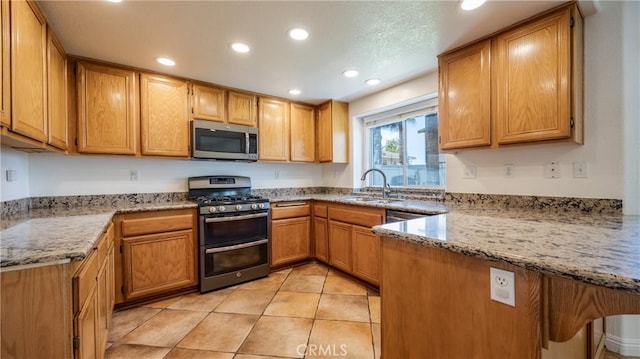 22820 Lark St, Grand Terrace, CA 92313 - kitchen featuring appliances with stainless steel finishes, a sink, recessed lighting, light stone counters, and a peninsula
