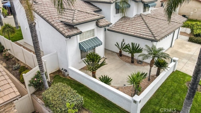 22820 Lark St, Grand Terrace, CA 92313 - view of side of home with stucco siding, a tiled roof, driveway, and a garage