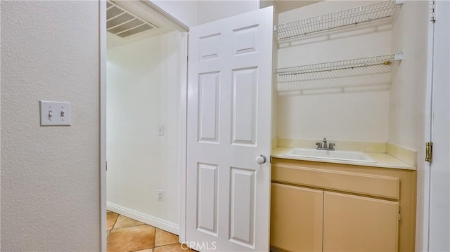 22820 Lark St, Grand Terrace, CA 92313 - bathroom with tile patterned floors, a textured wall, and vanity