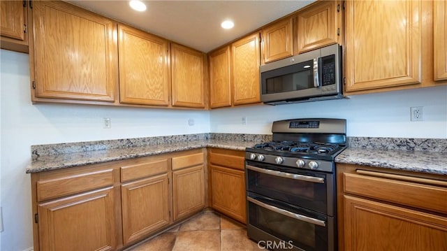 22820 Lark St, Grand Terrace, CA 92313 - kitchen with appliances with stainless steel finishes, recessed lighting, light tile patterned floors, light stone counters, and brown cabinets