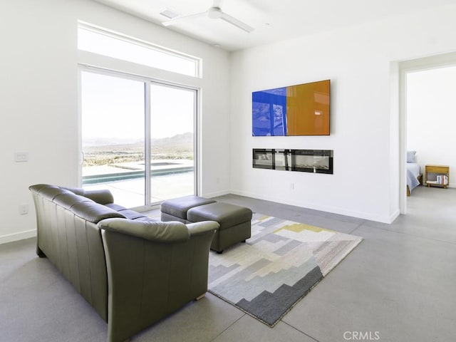 6197 Mandarin Rd, Yucca Valley, CA 92284 - living room with a ceiling fan, a glass covered fireplace, and baseboards