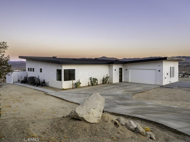 6197 Mandarin Rd, Yucca Valley, CA 92284 - view of front of home featuring an attached garage, central AC, stucco siding, and driveway