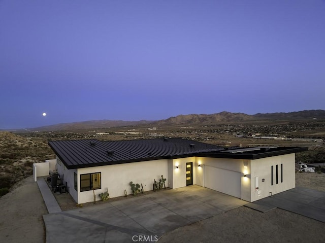 6197 Mandarin Rd, Yucca Valley, CA 92284 - view of front of home with a patio area, a mountain view, stucco siding, metal roof, and driveway