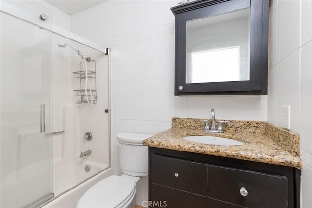 10709 Calabash Ave, Fontana, CA 92337 - bathroom featuring vanity, toilet, shower / bath combination with glass door, and tile walls