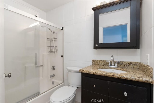 10709 Calabash Ave, Fontana, CA 92337 - bathroom featuring toilet, vanity, enclosed tub / shower combo, and tile walls