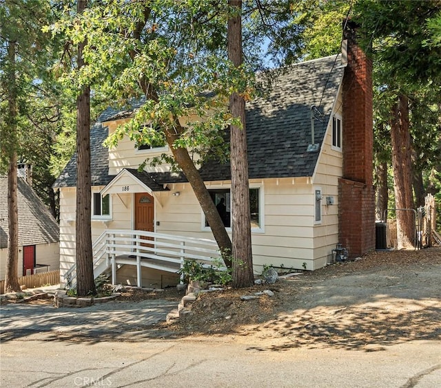 186 Hemlock Dr, Lake Arrowhead, CA 92352 - view of front of house featuring a shingled roof and a chimney
