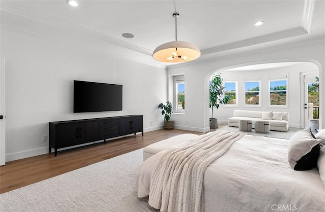 31 Harcourt, Newport Coast, CA 92657 - bedroom featuring arched walkways, crown molding, wood finished floors, a tray ceiling, and multiple windows