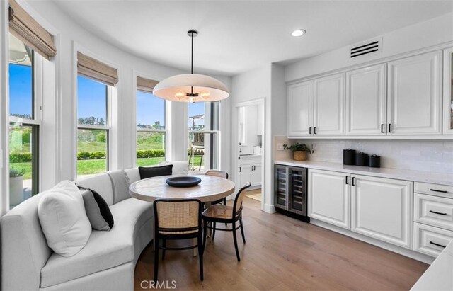 31 Harcourt, Newport Coast, CA 92657 - dining space featuring beverage cooler, recessed lighting, light wood finished floors, and bar area