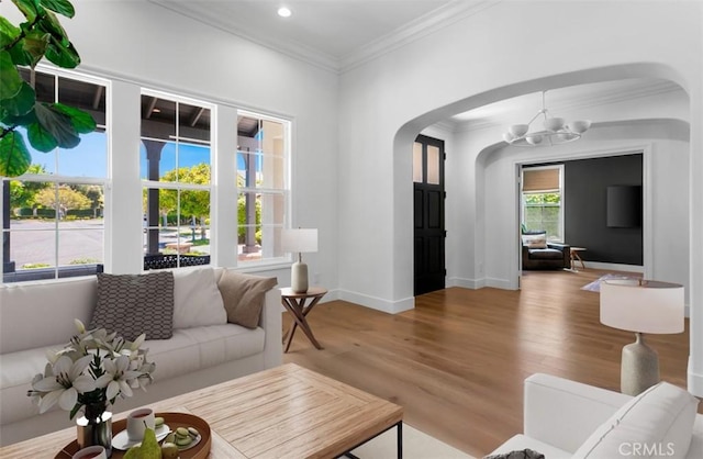 31 Harcourt, Newport Coast, CA 92657 - living area featuring arched walkways, wood finished floors, crown molding, a chandelier, and baseboards