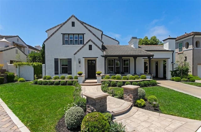 31 Harcourt, Newport Coast, CA 92657 - view of front facade with a chimney, stucco siding, a front lawn, and a tiled roof