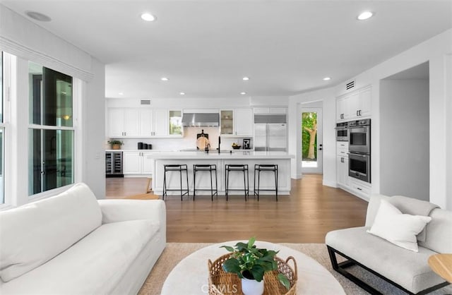 31 Harcourt, Newport Coast, CA 92657 - living room with beverage cooler, light wood-style floors, and recessed lighting