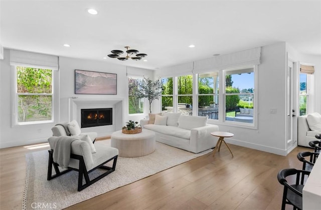 31 Harcourt, Newport Coast, CA 92657 - living area with a warm lit fireplace, wood finished floors, baseboards, and recessed lighting