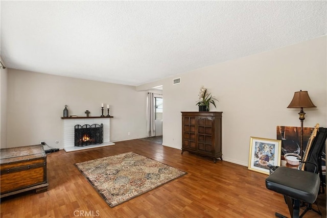 9861 E Lemon Ave, Arcadia, CA 91007 - living room with wood finished floors, a brick fireplace, and a textured ceiling