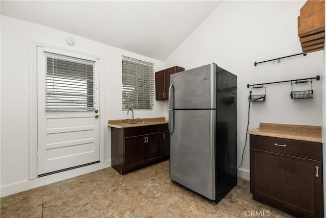 9861 E Lemon Ave, Arcadia, CA 91007 - kitchen featuring freestanding refrigerator, vaulted ceiling, dark brown cabinetry, a sink, and light countertops