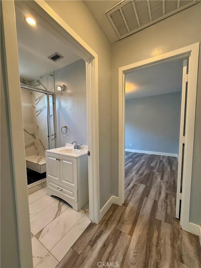 5472 3rd Ave, Los Angeles, CA 90043 - full bath with a marble finish shower, vanity, wood finished floors, and baseboards