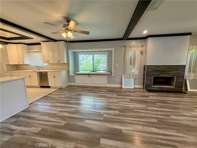 5472 3rd Ave, Los Angeles, CA 90043 - kitchen with dishwasher, a fireplace, white cabinetry, a ceiling fan, and light countertops