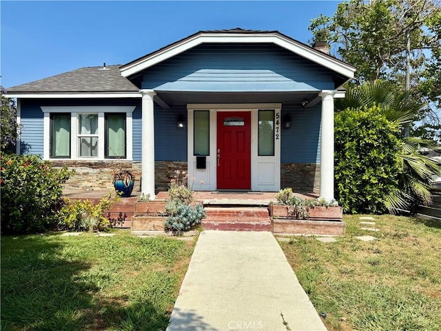 5472 3rd Ave, Los Angeles, CA 90043 - view of front of home featuring stone siding, a front yard, a porch, a chimney, and a shingled roof