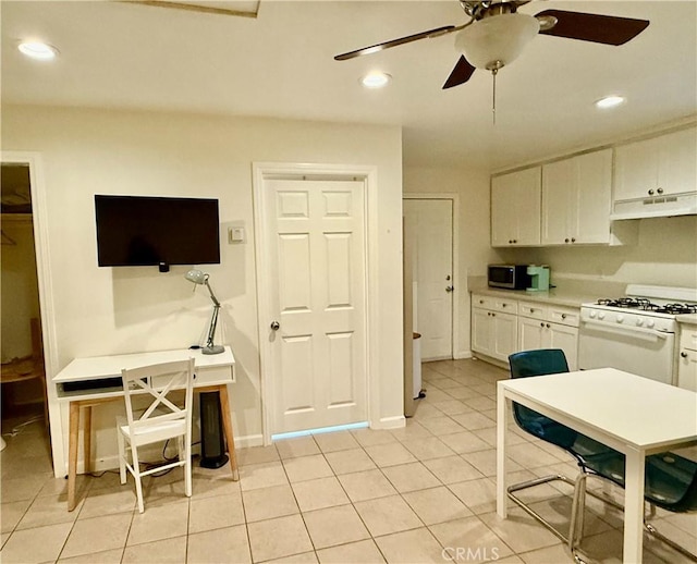 5472 3rd Ave, Los Angeles, CA 90043 - kitchen with white gas range, under cabinet range hood, white cabinetry, a ceiling fan, and light tile patterned floors