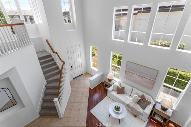 25815 Forsythe Way, Stevenson Ranch, CA 91381 - living room featuring a high ceiling, light tile patterned floors, stairs, and baseboards