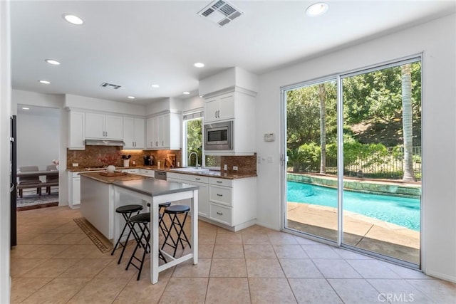 25815 Forsythe Way, Stevenson Ranch, CA 91381 - kitchen featuring under cabinet range hood, appliances with stainless steel finishes, tasteful backsplash, a sink, and recessed lighting