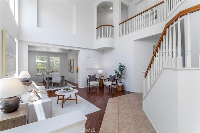 25815 Forsythe Way, Stevenson Ranch, CA 91381 - living room featuring stairs, a high ceiling, wood finished floors, and baseboards