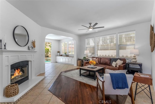 25815 Forsythe Way, Stevenson Ranch, CA 91381 - living room with ceiling fan, light tile patterned flooring, arched walkways, and a glass covered fireplace