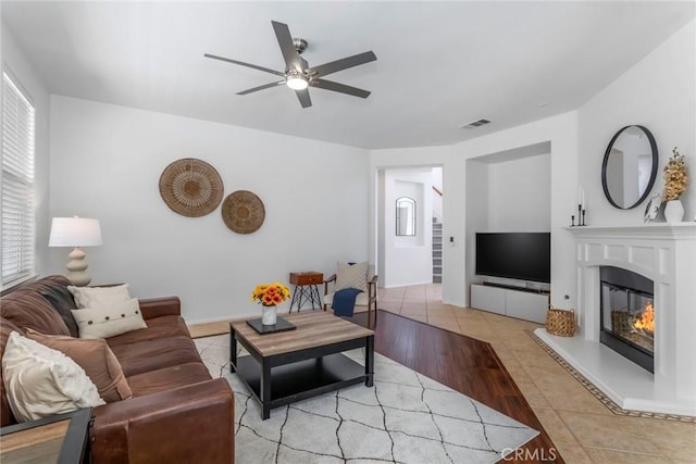 25815 Forsythe Way, Stevenson Ranch, CA 91381 - living room with ceiling fan, a glass covered fireplace, and light tile patterned floors