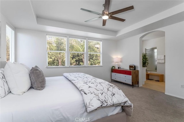 25815 Forsythe Way, Stevenson Ranch, CA 91381 - carpeted bedroom with arched walkways, a tray ceiling, multiple windows, and ceiling fan