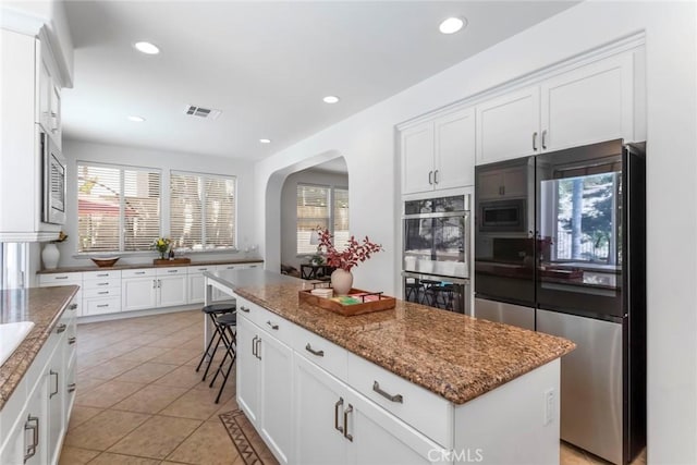 25815 Forsythe Way, Stevenson Ranch, CA 91381 - kitchen featuring stainless steel appliances, arched walkways, plenty of natural light, light tile patterned floors, and recessed lighting