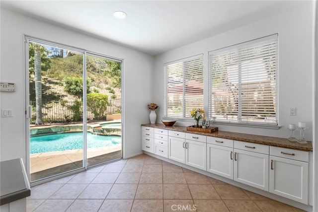25815 Forsythe Way, Stevenson Ranch, CA 91381 - interior space featuring healthy amount of natural light, white cabinetry, dark stone counters, and light tile patterned flooring