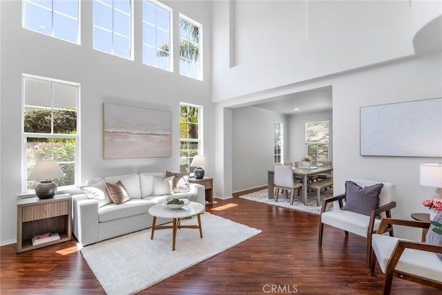 25815 Forsythe Way, Stevenson Ranch, CA 91381 - living room featuring dark wood-style flooring, a high ceiling, and baseboards