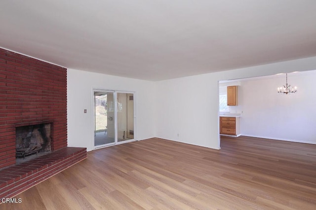 5020 Carolyn Way, Glendale, CA 91214 - unfurnished living room with a chandelier, light wood finished floors, a brick fireplace, and healthy amount of natural light