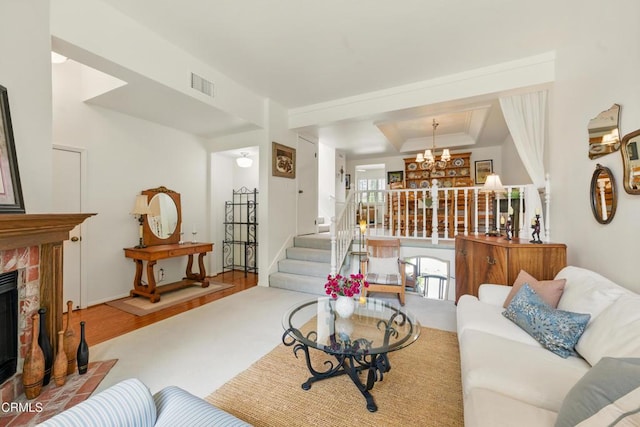 18751 Hatteras St Unit 13, Tarzana, CA 91356 - living area featuring a chandelier, a tray ceiling, a fireplace with flush hearth, stairway, and wood finished floors