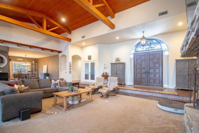11606 Mesa Verde Dr, Valley Center, CA 92082 - carpeted living room with wooden ceiling with exposed beams, high vaulted ceiling, healthy amount of natural light, a chandelier, and arched walkways