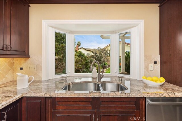 29162 Bobolink Dr, Laguna Niguel, CA 92677 - kitchen with a sink, dishwasher, decorative backsplash, dark brown cabinets, and light stone counters