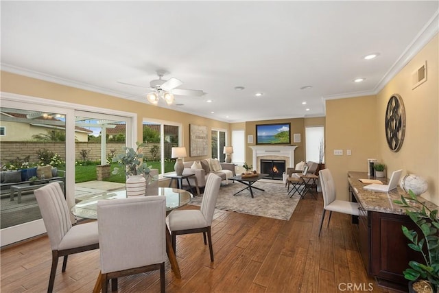 29162 Bobolink Dr, Laguna Niguel, CA 92677 - dining area featuring a warm lit fireplace, dark wood-type flooring, crown molding, ceiling fan, and recessed lighting