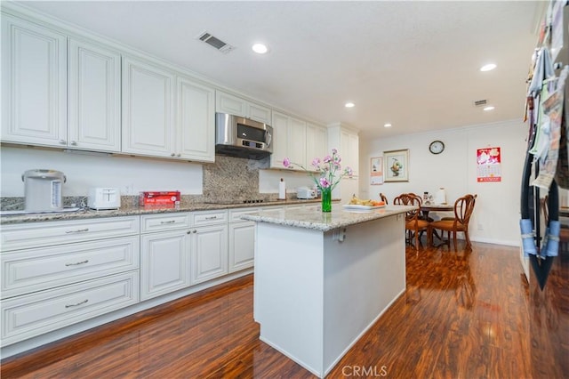 1855 Turnbull Canyon Rd, Hacienda Heights, CA 91745 - kitchen featuring stainless steel microwave, white cabinets, a center island, dark wood-style floors, and ornamental molding