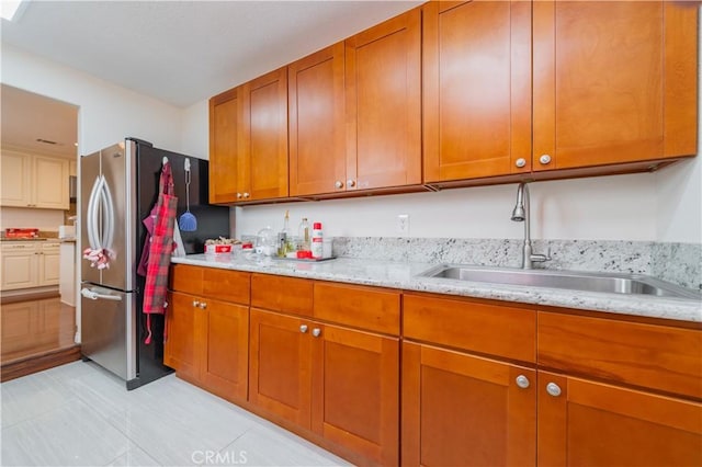1855 Turnbull Canyon Rd, Hacienda Heights, CA 91745 - kitchen with freestanding refrigerator, a sink, brown cabinetry, and light stone counters