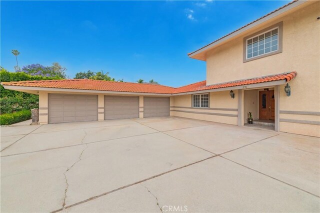 1855 Turnbull Canyon Rd, Hacienda Heights, CA 91745 - view of front facade with stucco siding, concrete driveway, a tiled roof, and an attached garage