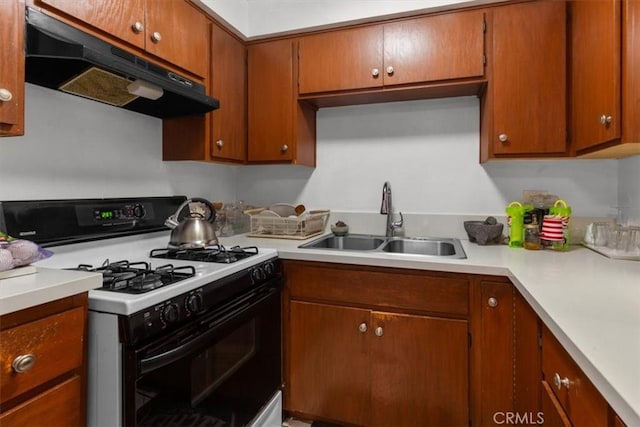 12912 Lariat Ln, Norwalk, CA 90650 - kitchen featuring range with gas cooktop, under cabinet range hood, a sink, light countertops, and brown cabinets