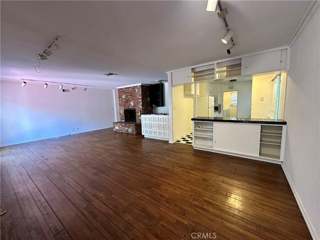 14655 Morrison St, Sherman Oaks, CA 91403 - unfurnished living room with rail lighting, a brick fireplace, and dark wood-type flooring