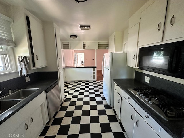 14655 Morrison St, Sherman Oaks, CA 91403 - kitchen featuring stainless steel appliances, dark flooring, dark countertops, and white cabinetry