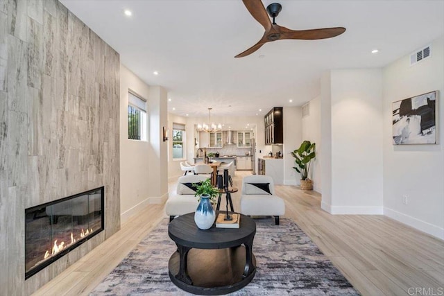 3285 5th Ave, San Diego, CA 92103 - living area featuring a chandelier, recessed lighting, ceiling fan, a tiled fireplace, and light wood finished floors