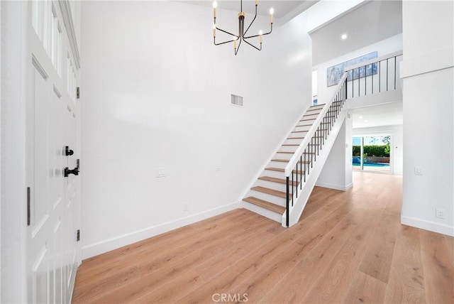 27591 Cenajo, Mission Viejo, CA 92691 - foyer featuring stairs, a chandelier, light wood-style flooring, baseboards, and a towering ceiling