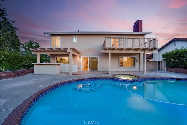 27591 Cenajo, Mission Viejo, CA 92691 - back of property at dusk with a balcony, a patio, a chimney, a pergola, and stucco siding