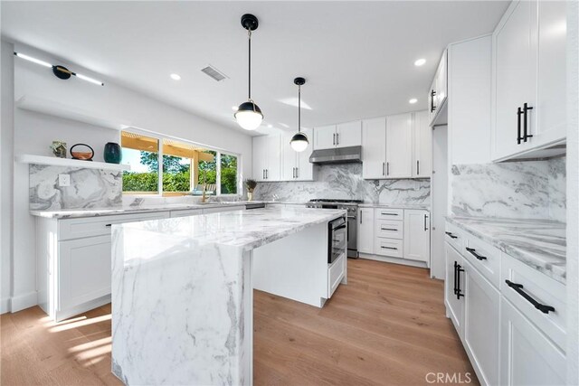 27591 Cenajo, Mission Viejo, CA 92691 - kitchen with open shelves, a center island, under cabinet range hood, stainless steel range, and tasteful backsplash