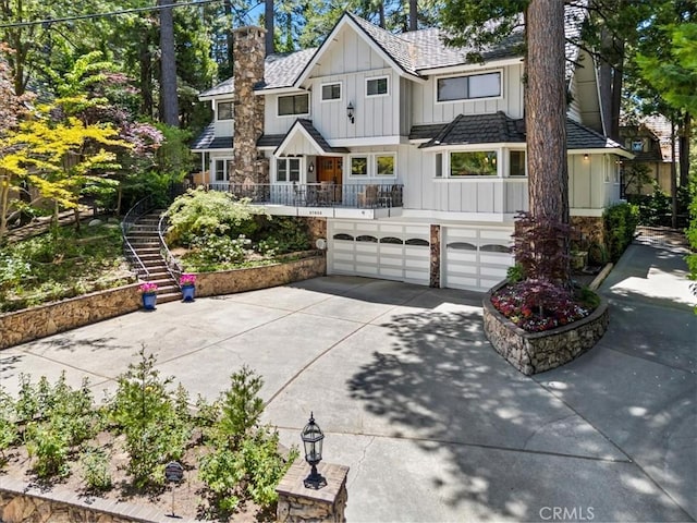 27833 Hamiltair Dr, Lake Arrowhead, CA 92352 - view of front of home featuring board and batten siding, driveway, a garage, stairs, and a chimney