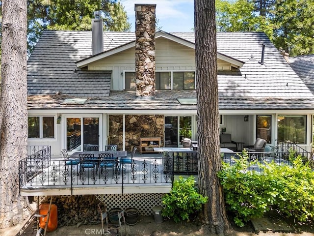 27833 Hamiltair Dr, Lake Arrowhead, CA 92352 - rear view of property with a wooden deck, outdoor dining area, a chimney, stone siding, and outdoor lounge area